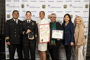 A group of people smiling and holding up a few awards.