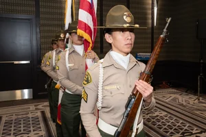 Military person holding a rifle.