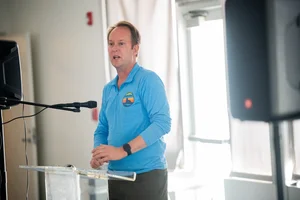 a man speaking at the podium at the event