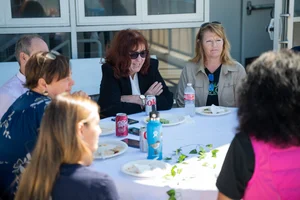 a group of people sitting at a table outside