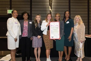 a group smiling and holding up an award.