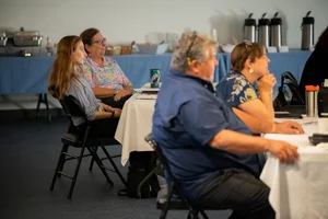 a group of people sitting at tables at an event.