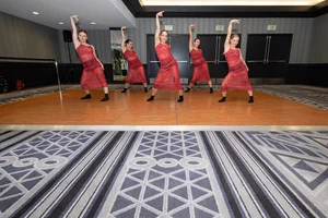 5 women dressed in red posing for a performance.