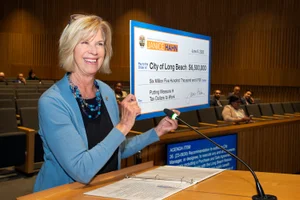 Supervisor Hahn posing with a check in the board meeting room