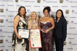 4 women smiling and holding up a few awards.