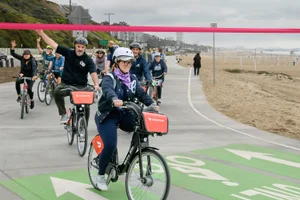 Supervisor Horvath in a group riding bikes by the beach