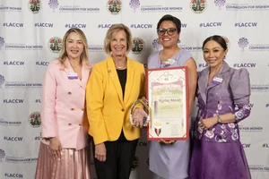 Supervisor Hahn smiling for a photo with 3 other women while they hold up a couple of awards.