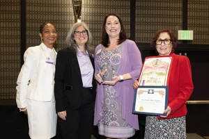 a group of women holding up a few awards.