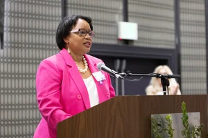 Woman in pink speaking at a podium.