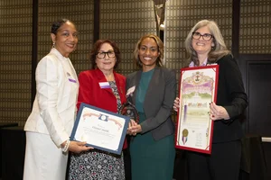 a group of women holding up a couple awards.