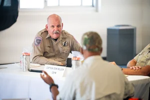 2 people sitting down and speaking to each other at event