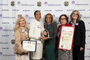 5 women smiling and holding up a few awards.