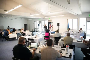a group of people sitting at tables at an event.