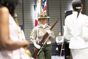 a county officer holding a rifle.