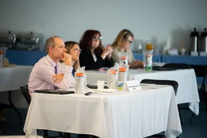 a group of people sitting at tables at an event.