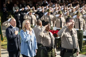 Supervisor Barger pledge of allegiance while surrounded by officers saluting