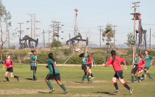Two girls soccer teams playing against each other.