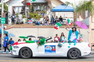 Supervisor Solis waving from a car in the street during a parade