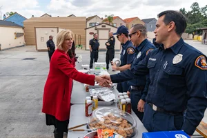 Supervisor Hahn shaking hands with firemen outside their station