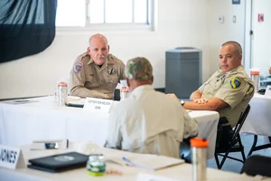 3 people sitting down and speaking to each other at event