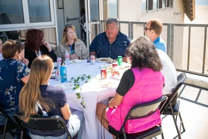 a group of people sitting at a table outside
