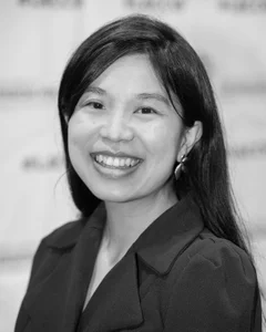 Woman smiling for a photo in black and white.