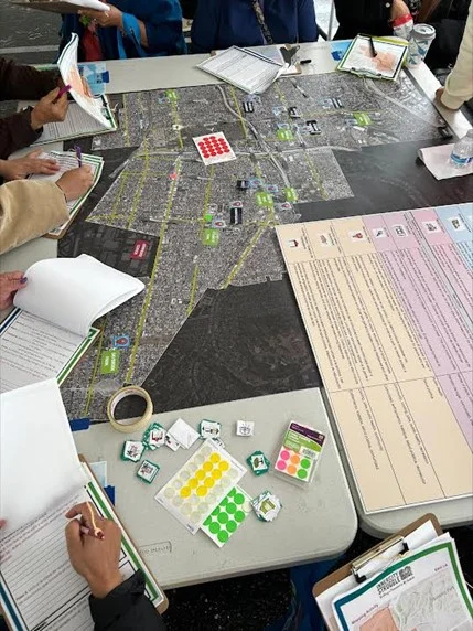 Top view of a group creating city plans with a map layout and documents all over the table.