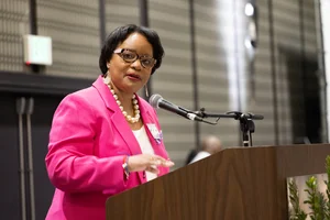 Woman in pink speaking at a podium.