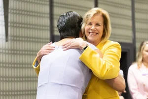Supervisor Hahn hugging someone at a podium.