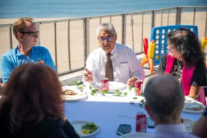 a group of people sitting at a table outside