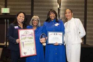 a group of women holding up a few awards.