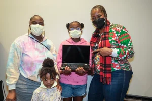 Supervisor Mitchell group photo pointing at a laptop