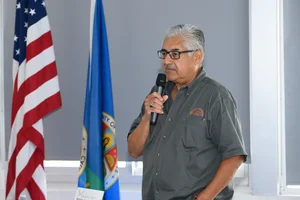 a man speaking on stage at the event into a microphone