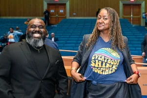 Supervisor Mitchell showing off her shirt in a picture with a man in the board room