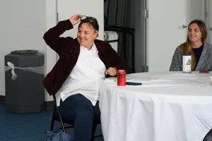2 women sitting at a table at the event.