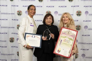 3 women smiling for a group photo while they each hold up an award.
