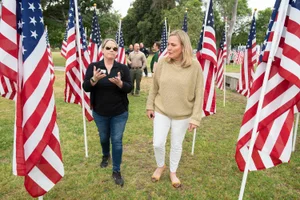 Supervisor Barger speaking to a woman surrounded by multiple American flags