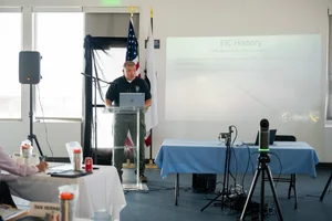 a man speaking at the podium at the event