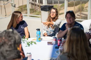 a group of people sitting at a table outside
