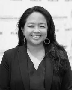 Woman smiling for a photo in black and white.