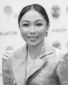 Woman smiling for a photo in black and white.