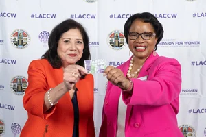 Supervisor Holis and another woman smiling and holding up a ticket.