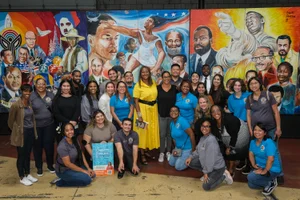 Supervisor Mitchell in a large group photo in front of art