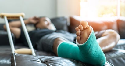 Male patient with splint cast and crutches during surgery rehabilitation.  Find Group short term disability insurance.