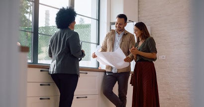 Real estate agent and a couple in the kitchen of a new house. How to Purchase a Home: A Step-by-Step Guide.