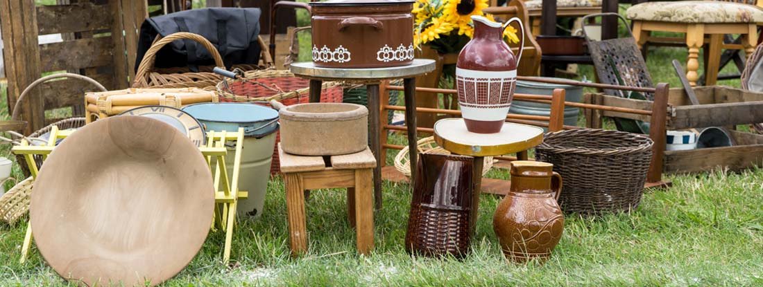 Flea market stall with vases, dishes, furniture and crates. Find Antique Dealer Insurance.