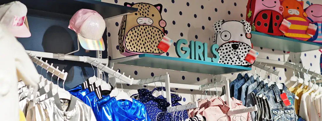 Children's bright clothes hang on the display in the baby clothing store. Find Children and Baby Clothes Store Insurance. 