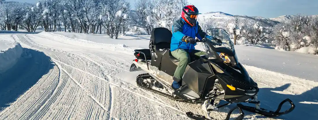 Man driving a snowmobile. Find Snowmobile Insurance Claims.