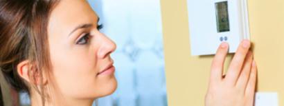 woman checking thermostat