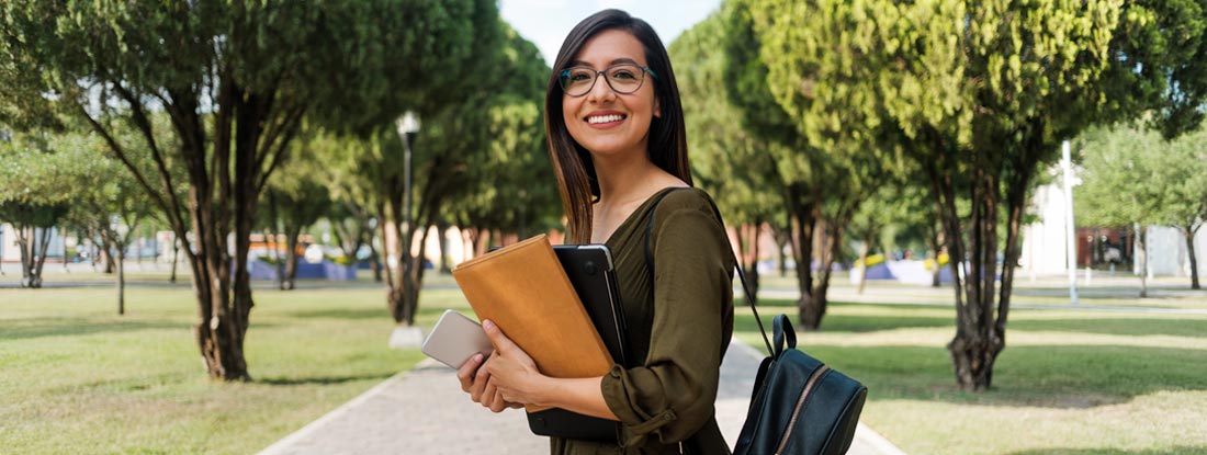Female college student on campus. College Student Health Insurance.